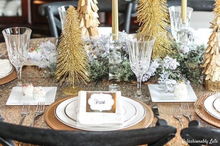 gold sequin tablecloth with gold chargers and white plates and gold trees with other gold white and green accents