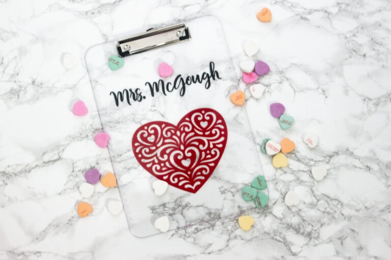 DIY personalized clipboard with marble background and heart and font on the clipboard surrounded by candy hearts