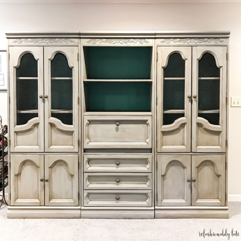 grey hutch with a blue back sitting in a family room