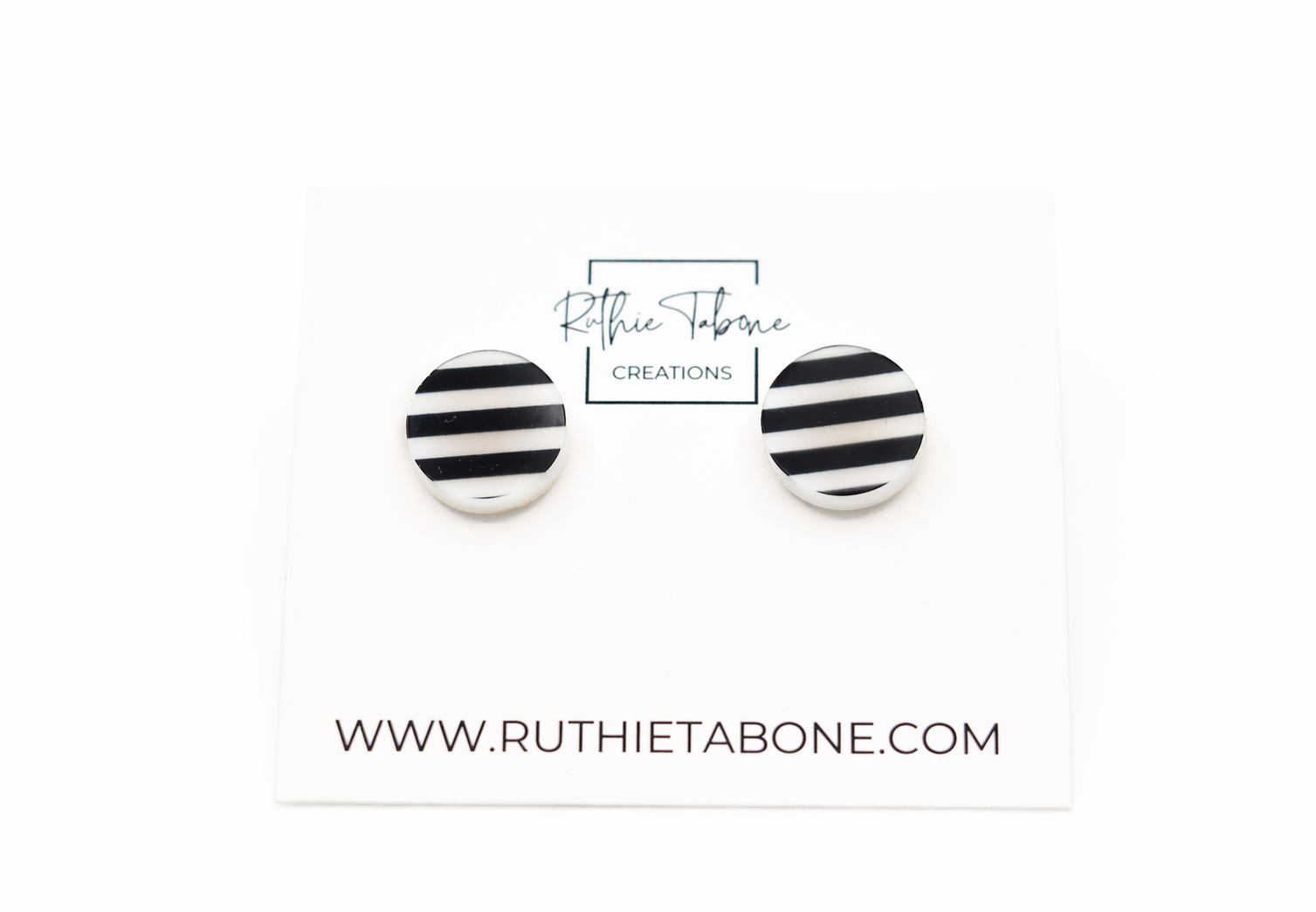 Black and white striped round stud earrings displayed on a Ruthie Tabone Creations card, photographed on a clean white background.