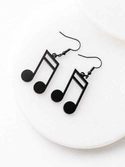 Black music note dangle earrings with stainless steel hooks on a white display
