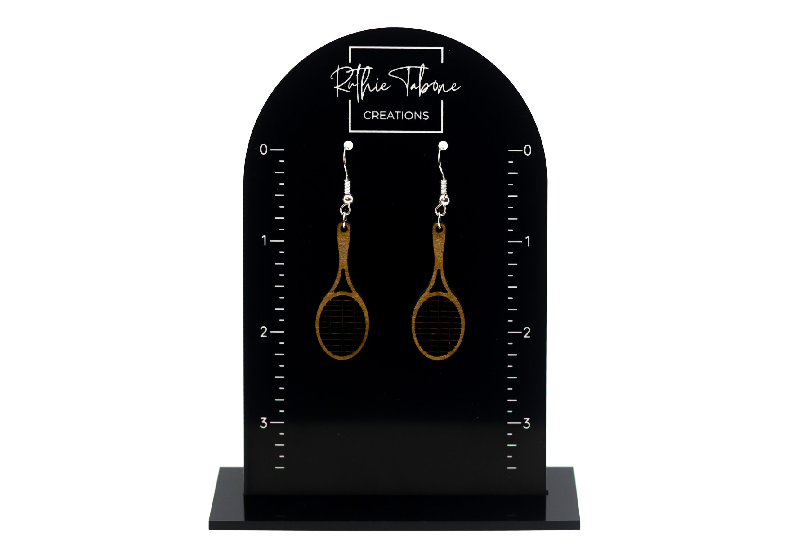 Wood racket dangle earrings with dark string detail and silver hooks displayed on a black Ruthie Tabone Creations earring card with measurement markings.