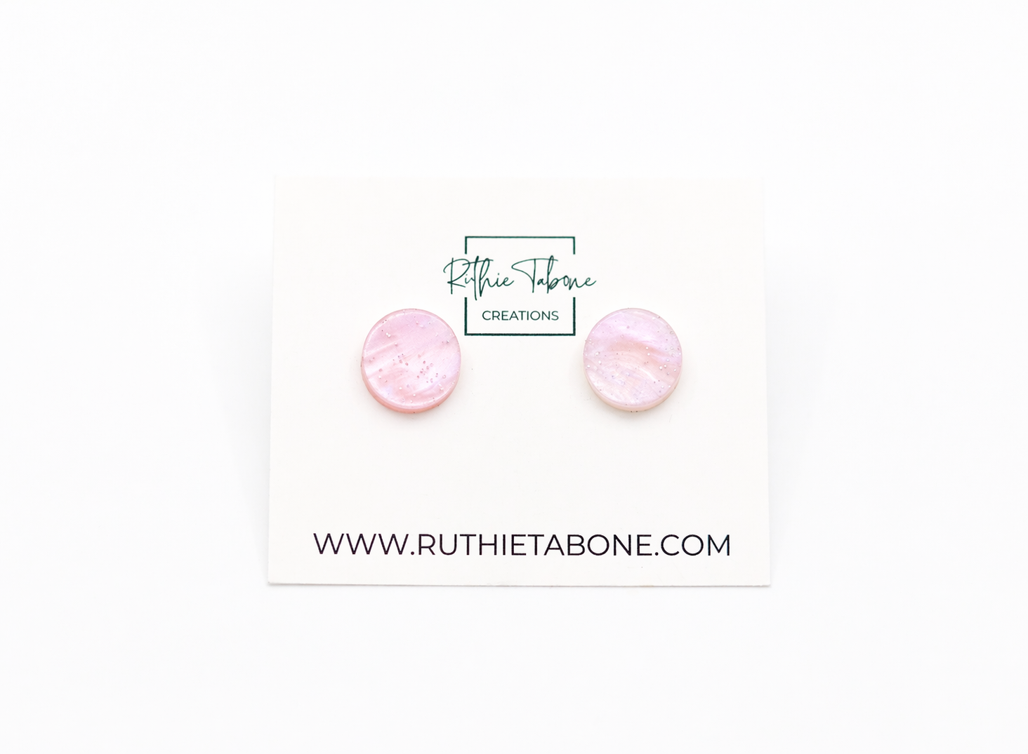 Pink marbled round stud earrings with subtle shimmer, displayed on a Ruthie Tabone Creations card against a clean white background.