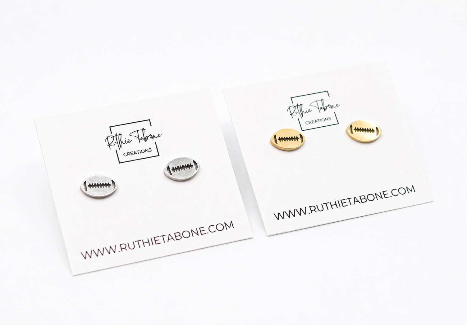 Two pairs of football stud earrings displayed on Ruthie Tabone Creations cards, featuring silver and gold oval designs with engraved lace detailing on a clean white background.
