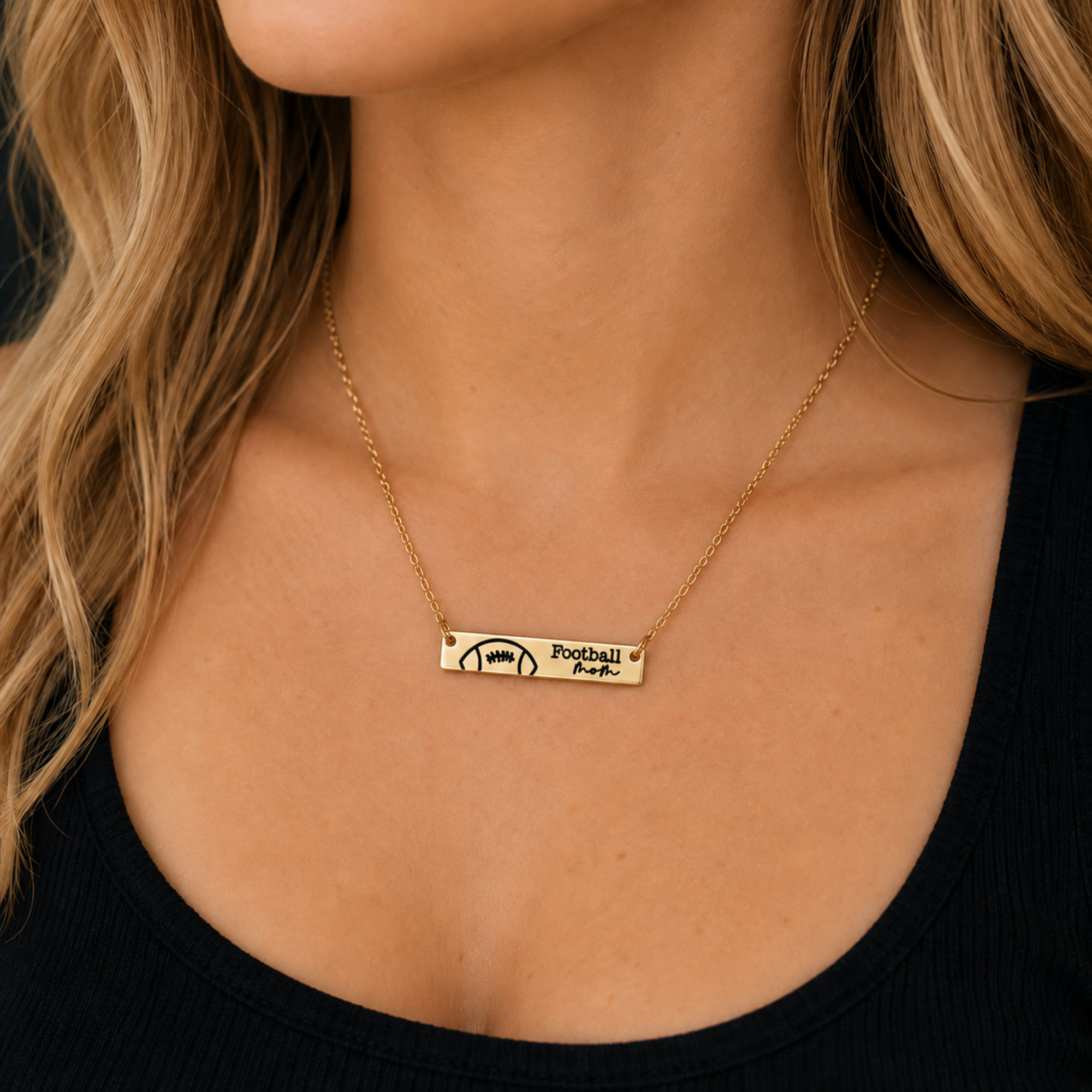 Gold Football Mom engraved bar necklace modeled on a woman, featuring a football design and delicate gold chain for sports moms and game day jewelry.